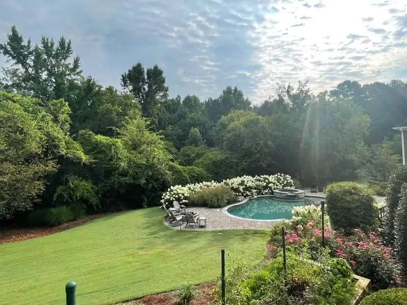 Backyard lawn maintenance near pool area