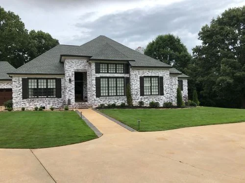 Manicured front lawn with curved driveway