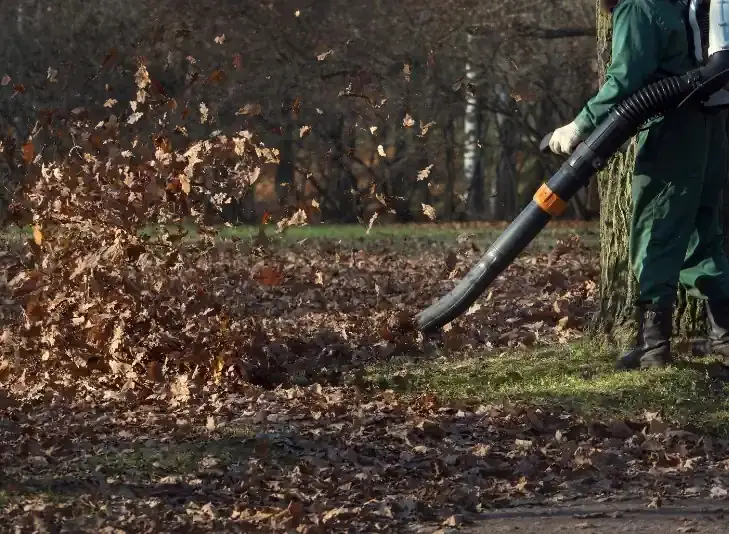 Crew member using leaf blower